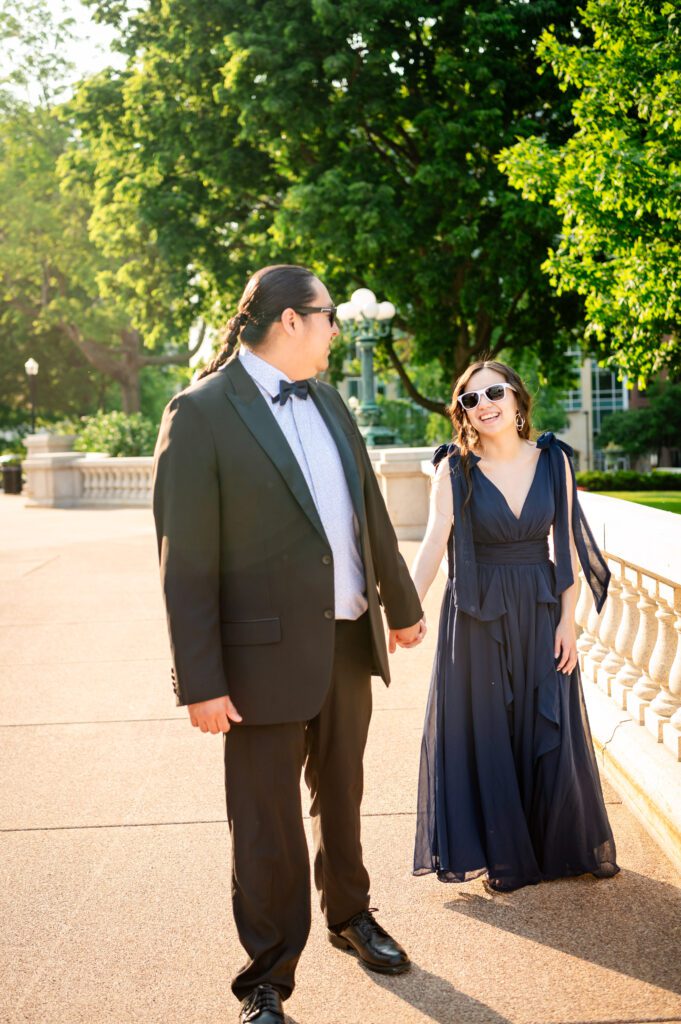 Close-up of Autumn and Michael holding hands in campus setting