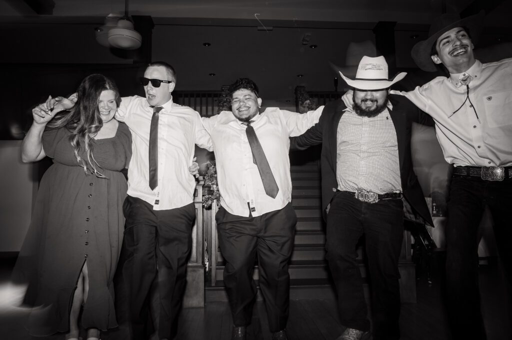 Guests dancing in cowboy hats during a Latino-inspired wedding reception at Chorus Public House in Stoughton, WI.