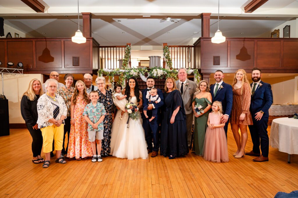 Family group photo taken after the ceremony, capturing smiles and love as the newlyweds celebrate with their loved ones.