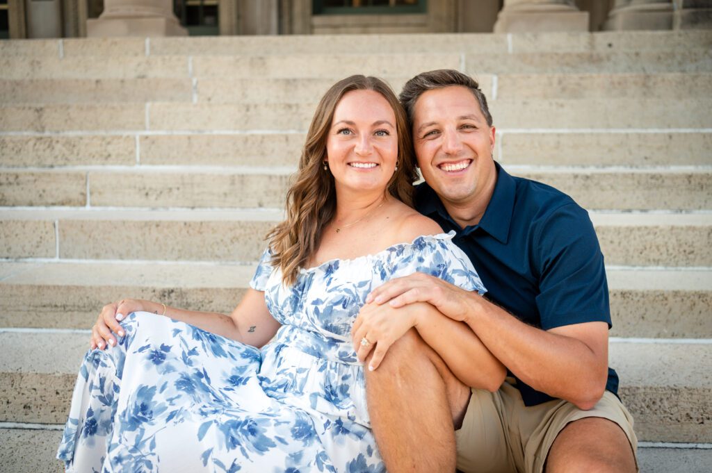 Couple smiling on the steps of the Wisconsin State Capitol during their Madison engagement session.