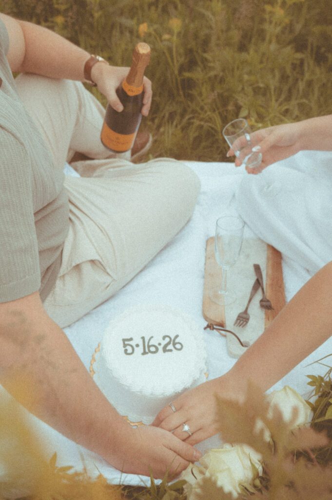 Couple sharing wine during picnic engagement photos at Pope Farm in Middleton WI