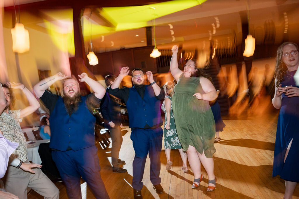 Wedding guests dancing energetically under colorful lights during Marissa and Jared’s Dungeons & Dragons themed reception at Chorus Public House.